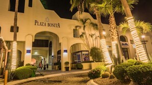 The exterior of Plaza Bonita with arched entrances, palm trees, and illuminated signage. - Stunning Marina views, best location in Cabo! (Cabo San Lucas)