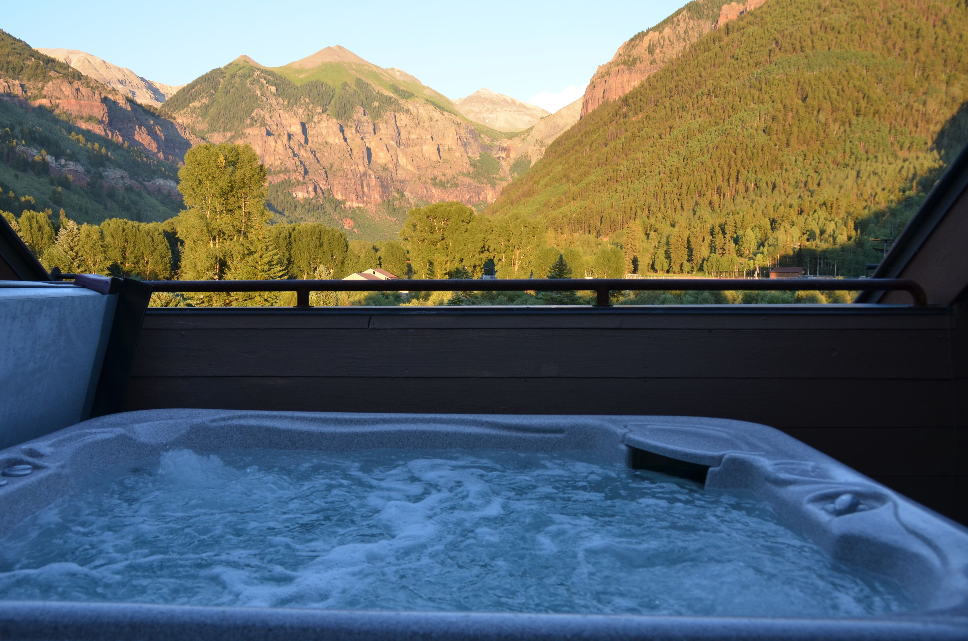 Un jacuzzi con vistas a montañas y árboles.