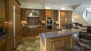 Een ruime keuken met houten kastjes, een granieten aanrechtblad en een ingebouwde oven.