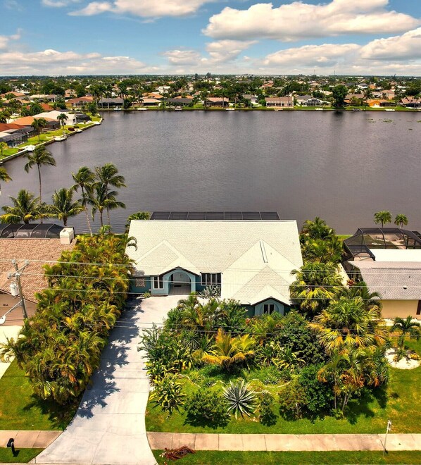 A residential area with a large body of water, houses, and lush greenery.