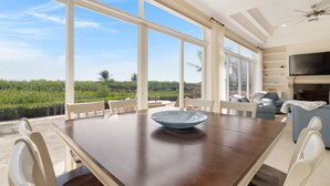 A spacious dining area with a large table and chairs, a television, and a fireplace.