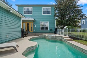 A two-story house with a swimming pool, a covered patio, and a fenced yard. - Patriot's Playa: Private Pool, Golf, Water Park, Near Disney (Kissimmee)
