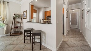 A kitchen with a built-in island, wooden cabinets, and a window with curtains.