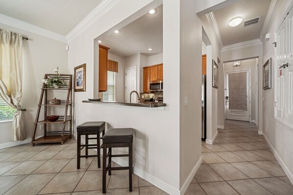 A kitchen with a built-in island, wooden cabinets, and a window with curtains.