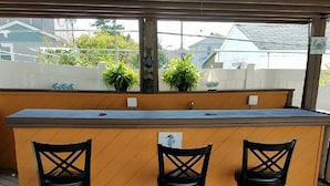 A bar area with a wooden deck, three black bar stools, and a counter. - The Carter's Wildwood Rentals-  Master Suite #3 (Wildwood)