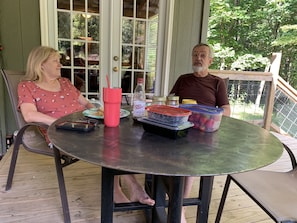 A round table with a metal frame, a red tumbler, a bottle of Dr. Pepper Diet, and containers of berries and yogurt. - Private 50 ft waterfall. Eco-friendly, cozy shipping container cabin (Tracy City)