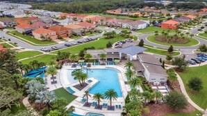 A residential area with a swimming pool, houses, and a road. - Amazing 5 bedroom house near Disney (Kissimmee)
