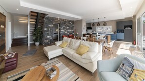 Ein modernes Wohnzimmer mit einer Couch, einem Couchtisch und einem Essbereich mit Stühlen und einem Tisch.