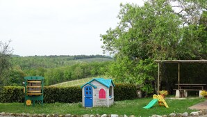 A children's play area with a small house, a slide, and a green structure. - MONTEGONFOLI 2 Apartment in countryside of San Gimignano with amazing views 4+2 (san gimignano)