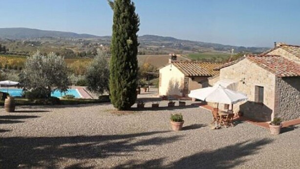 A rustic stone building with a tiled roof, a swimming pool, and a tall cypress tree in a rural setting. - MONTEGONFOLI 2 Apartment in countryside of San Gimignano with amazing views 4+2 (san gimignano)