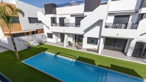 Un edificio moderno de varios pisos con piscina y césped cuidado.