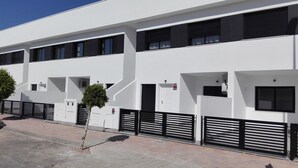 Un edificio moderno con varios accesos, cada uno con puerta y ventana.