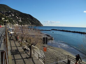 A coastal promenade with a stone walkway, a beach, and a rocky breakwater. - RELAX & LOT OF LIGHT NEAR THE BEACH (Moneglia)