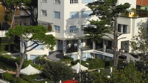 Un immeuble résidentiel à plusieurs étages, doté de balcons, entouré de verdure et d’autres immeubles résidentiels.