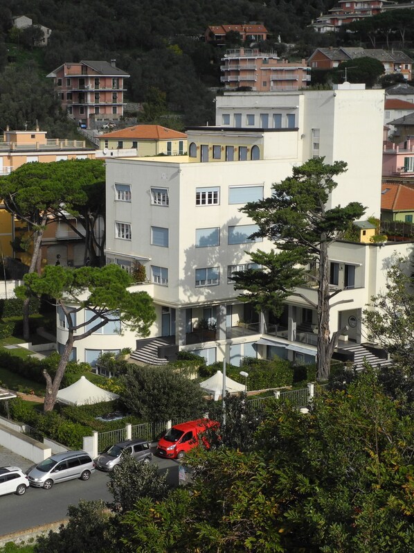 Un immeuble résidentiel à plusieurs étages, doté de balcons, entouré de verdure et d’autres immeubles résidentiels.