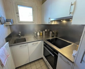 A compact kitchen with a sink, stove, and cabinets. - Chalet Les Fétiches - Anzère - Valais - Switzerland (Swiss Alps) (Anzere)