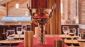 A dining table set with wine glasses, plates, and a central decorative bowl.