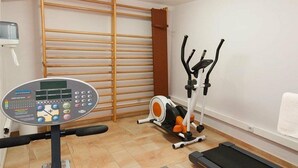 A home gym with a treadmill, elliptical, and resistance bands. - Villa Meloneras Hills 16 Holiday Rentals (San Bartolome de Tirajana)