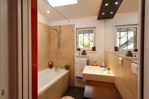 Bathtub, hair dryer, towels, toilet paper