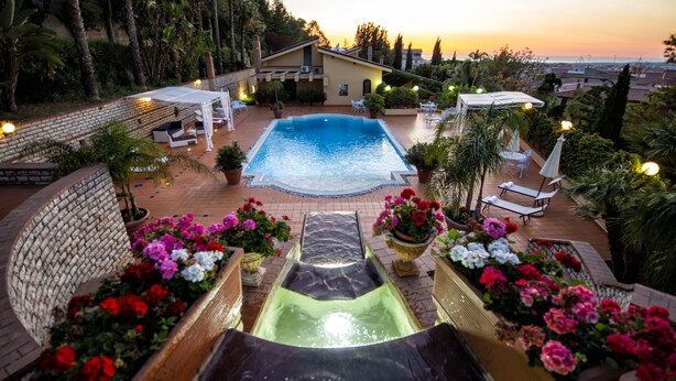 A swimming pool with a hot tub, surrounded by lounge chairs and potted plants. - Luxury SPA Villa with Private Pool, Jacuzzi,Pine Forest - Available for Weddings (Partinico)
