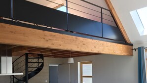 A spacious loft with a mezzanine, a staircase, a dining area, and a TV. - Wooden house, close to beaches and dunes (Landéda)