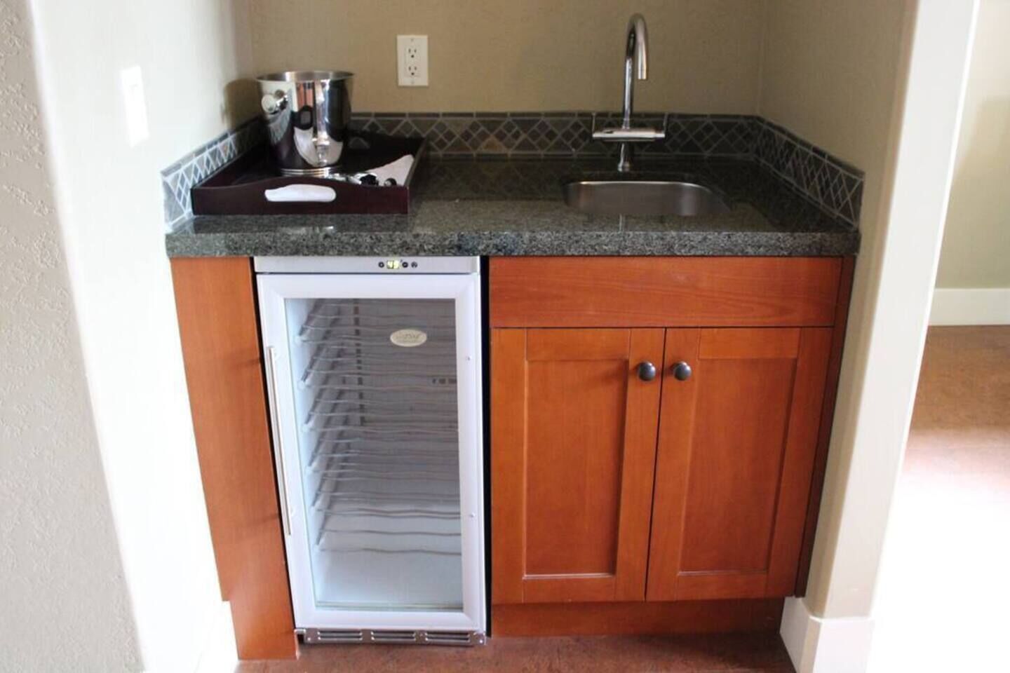 A compact kitchen with a built-in refrigerator, a sink, and a microwave.