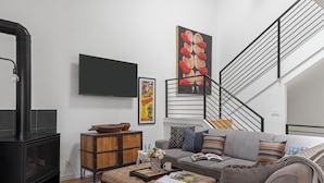 A modern living room with a fireplace, sofa, coffee table, and artwork. - Outpost: Clark's Knoll 385 - Walk to Town Square (Jackson)