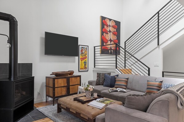 A modern living room with a fireplace, sofa, coffee table, and artwork. - Outpost: Clark's Knoll 385 - Walk to Town Square (Jackson)