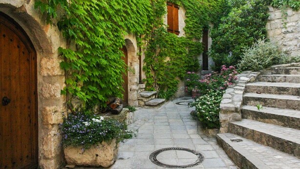 A narrow stone pathway leading to a wooden door, flanked by lush greenery and stone steps. - Charming cottage ****, near Montpellier and 20 'beaches (Prades-Le-Lez)