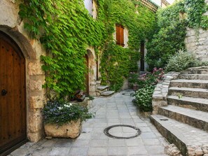 A narrow stone pathway leading to a wooden door, flanked by lush greenery and stone steps. - Charming cottage ****, near Montpellier and 20 'beaches (Prades-Le-Lez)