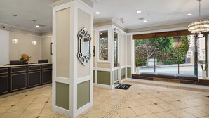 A hotel lobby with a reception desk, a large mirror, and a chandelier. - WorldMark San Francisco (San Francisco)