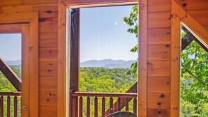 A wooden deck with a pool table, a chair, and a view of a forested landscape. - Resort setting w/ awesome Mtn views! Self checkin, close to Nat’l Park! Sleeps 6 (Pigeon Forge)