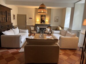 A living room with a checkered floor, two sofas, a wooden coffee table, and a chandelier.