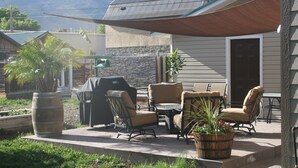 An outdoor patio with a grill, chairs, and a table. - Layton's Loft (Manti)
