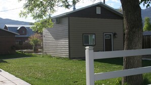 A single-story house with a front yard and a white fence. - Layton's Loft (Manti)