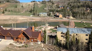A residential area with houses, a small lake, and a forested hill. - Luxury Condo in Brian Head,  Beautiful Amenities,  Easy Walk/Ski To Slopes (Brian Head)