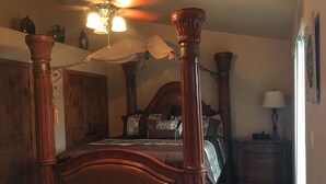 A four-poster bed with a wooden headboard, a ceiling fan, and a bedside table with a lamp. - Luxury Condo in Brian Head,  Beautiful Amenities,  Easy Walk/Ski To Slopes (Brian Head)