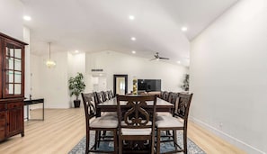 A dining area with a wooden table and chairs, a chandelier, and a ceiling fan. - Private Luxury 6BR Resort: Pool, Pickleball, Oasis (Scottsdale)