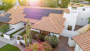 A residential building with a tiled roof, solar panels, and a cactus in the garden. - Private Luxury 6BR Resort: Pool, Pickleball, Oasis (Scottsdale)