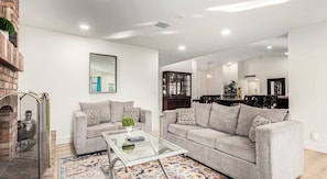 A living room with a sofa, coffee table, and a fireplace.