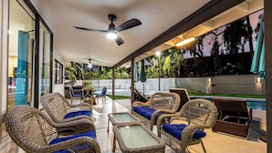 An outdoor patio with wicker furniture, a ceiling fan, and a pool. - Private Luxury 6BR Resort: Pool, Pickleball, Oasis (Scottsdale)