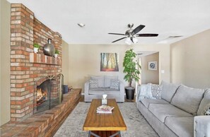 Relax in this inviting living room with a brick fireplace, sofa, and coffee table.