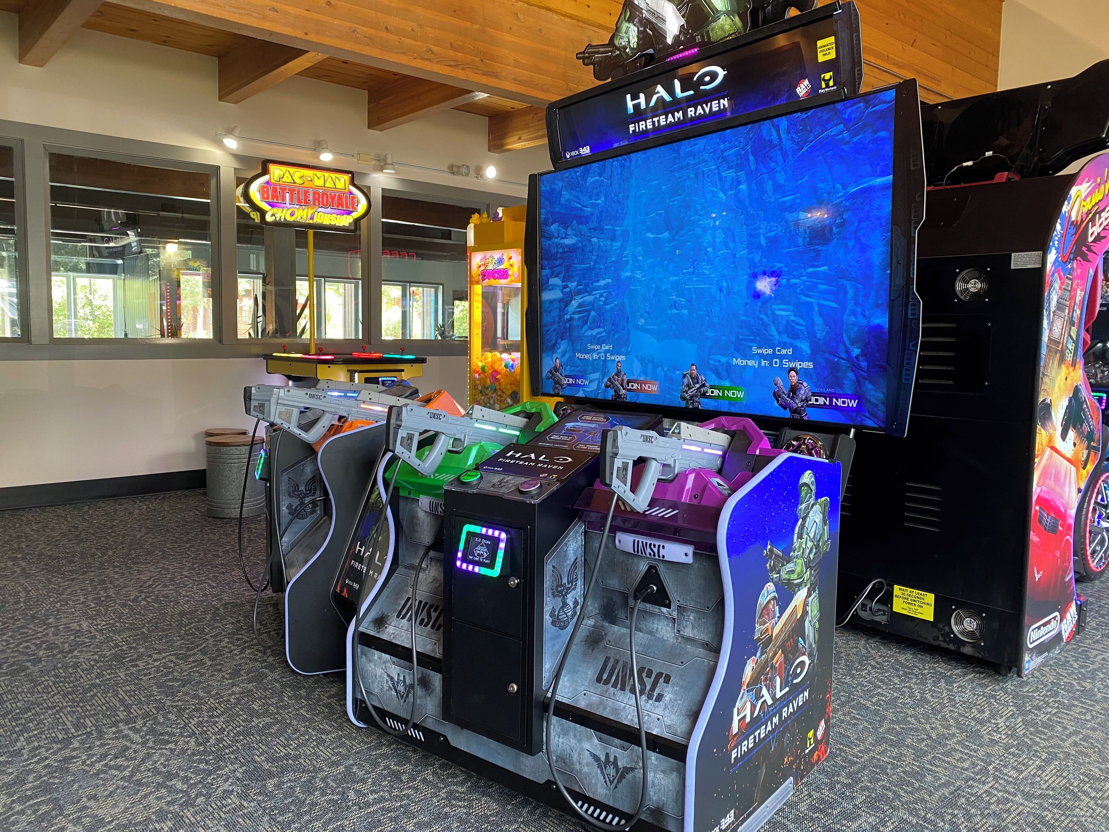 Un'area giochi con diverse macchine arcade, tra cui un setup Halo Fireteam Raven.