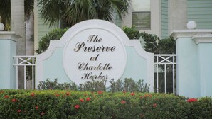 En skylt för The Preserve at Charlotte Harbor, med vit bakgrund och guldfärgad text.