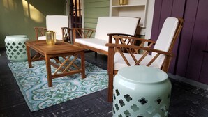 A patio area with a wooden table and chairs, a patterned rug, and decorative planters. - Riverbend Gem in Historic Carrollton Uptown  (New Orleans)