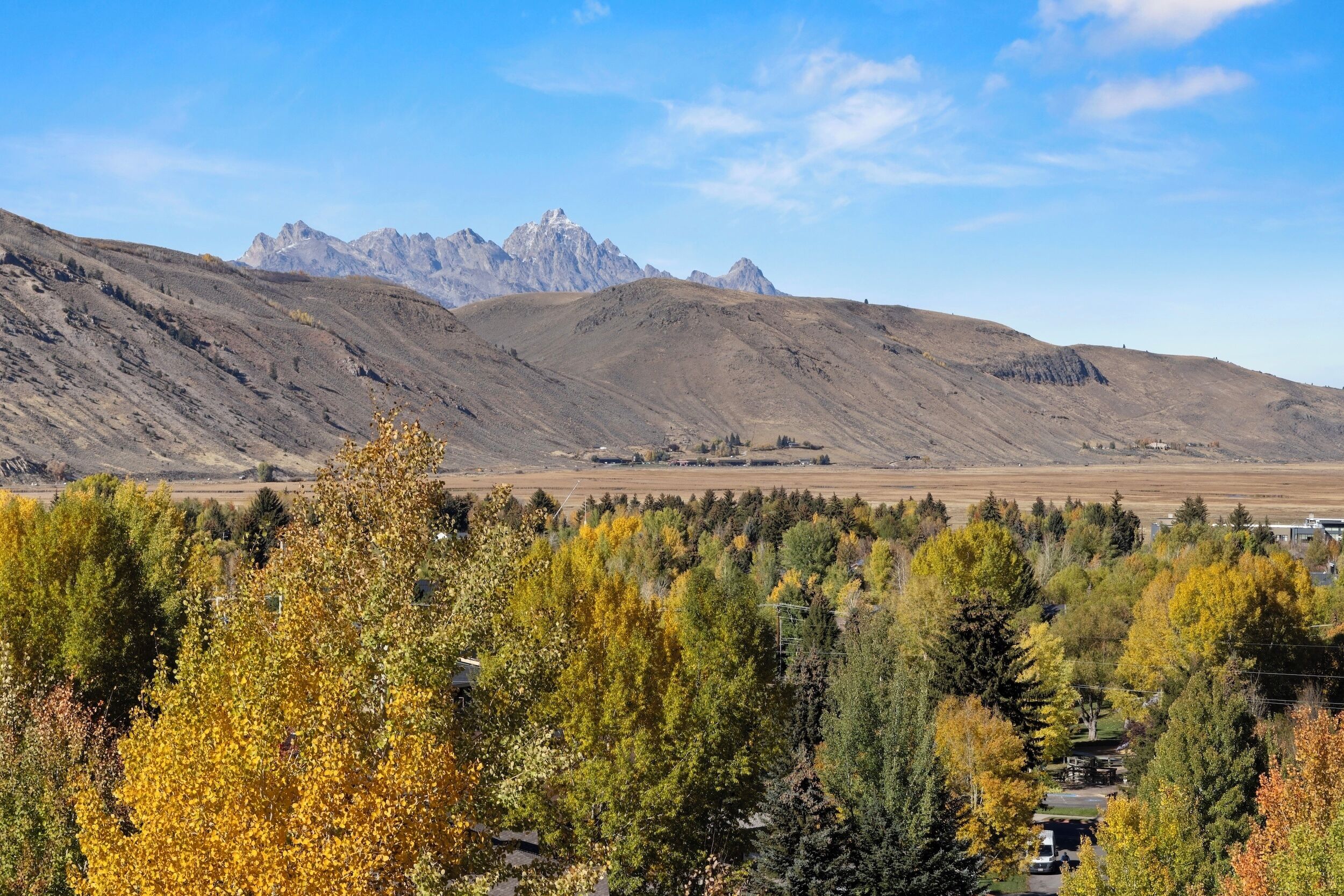 A mountainous landscape with autumn foliage and a clear sky.