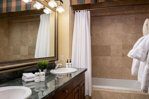Une salle de bain avec un lavabo, un miroir et un rideau de douche.