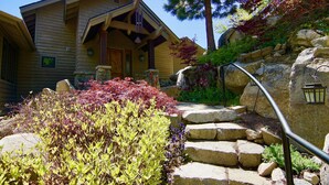 Una casa de madera con una escalera de piedra que sube a un porche.