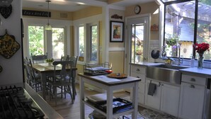A kitchen with a dining area, a gas stove, a sink, and a window with a view of greenery. - The Kenwood House - A Place to Stay
Your Wine Country Oasis in Sonoma Valley (Kenwood)