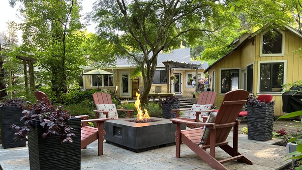A patio with a fire pit, outdoor furniture, and a view of a house. - The Kenwood House - A Place to Stay
Your Wine Country Oasis in Sonoma Valley (Kenwood)